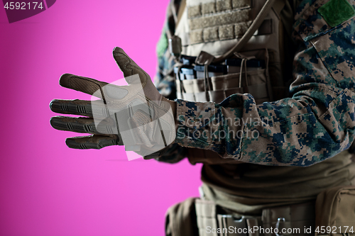 Image of closeup of soldier hands putting protective battle gloves pink b