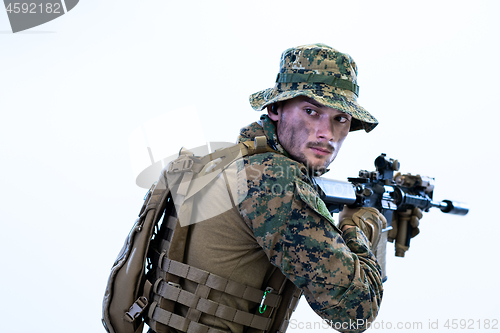 Image of soldier in action aiming laseer sight optics