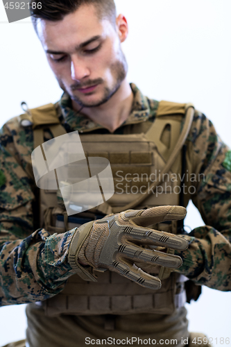 Image of closeup of soldier hands putting protective battle gloves