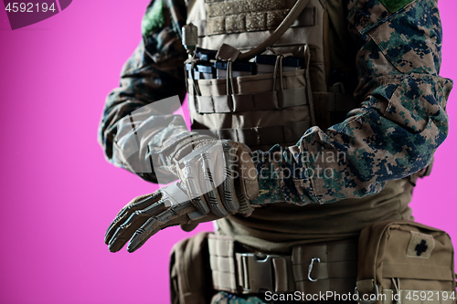 Image of closeup of soldier hands putting protective battle gloves pink b