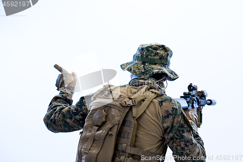 Image of soldier in action giving comands to team by hand sign