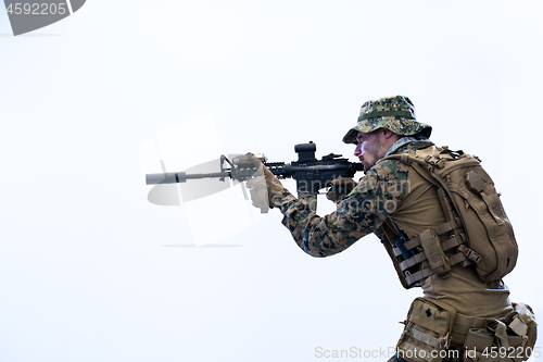 Image of soldier in action aiming laseer sight optics