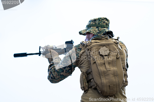 Image of soldier in action aiming laseer sight optics