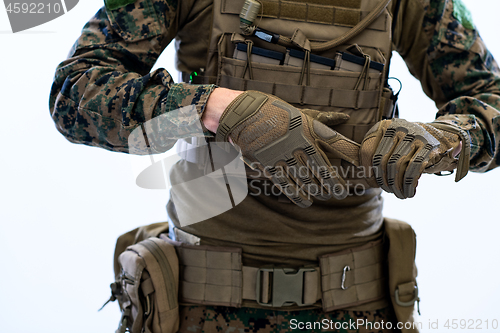 Image of closeup of soldier hands putting protective battle gloves