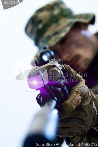 Image of soldier in action aiming laseer sight optics