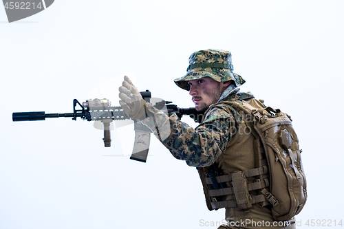 Image of soldier in action aiming laseer sight optics