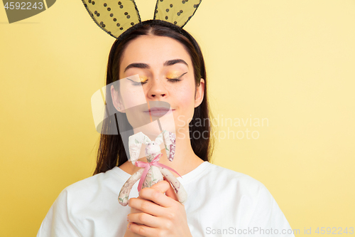 Image of Easter bunny woman with bright emotions on yellow studio background