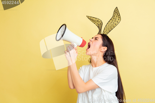 Image of Easter bunny woman with bright emotions on yellow studio background