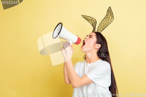 Image of Easter bunny woman with bright emotions on yellow studio background