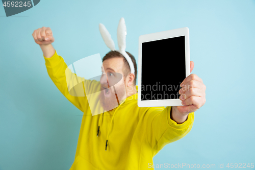 Image of Easter bunny man with bright emotions on blue studio background