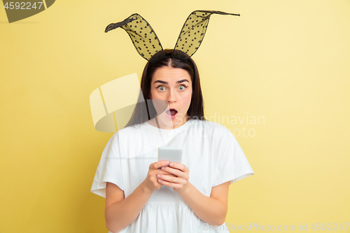 Image of Easter bunny woman with bright emotions on yellow studio background