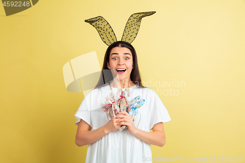 Image of Easter bunny woman with bright emotions on yellow studio background