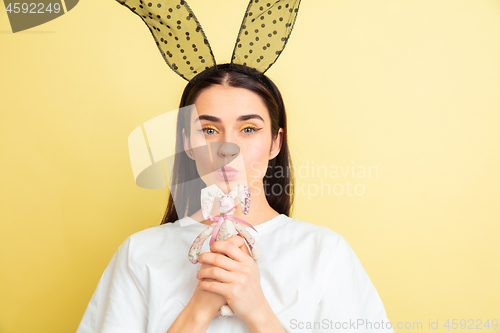 Image of Easter bunny woman with bright emotions on yellow studio background