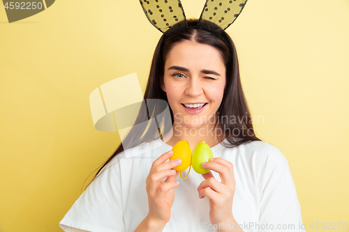 Image of Easter bunny woman with bright emotions on yellow studio background