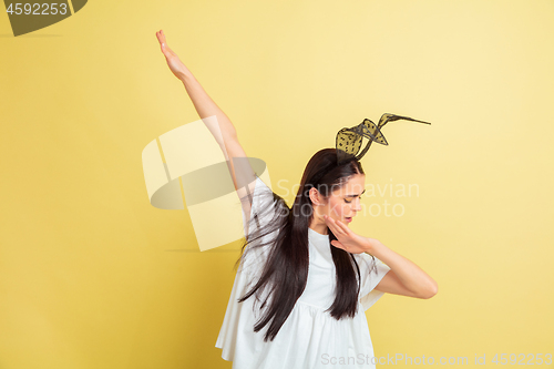 Image of Easter bunny woman with bright emotions on yellow studio background