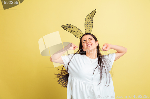 Image of Easter bunny woman with bright emotions on yellow studio background