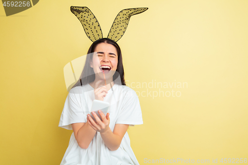 Image of Easter bunny woman with bright emotions on yellow studio background