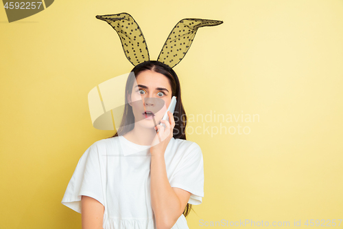 Image of Easter bunny woman with bright emotions on yellow studio background