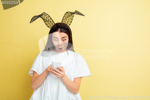 Image of Easter bunny woman with bright emotions on yellow studio background