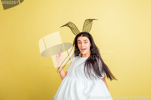 Image of Easter bunny woman with bright emotions on yellow studio background