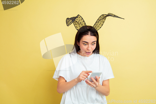 Image of Easter bunny woman with bright emotions on yellow studio background