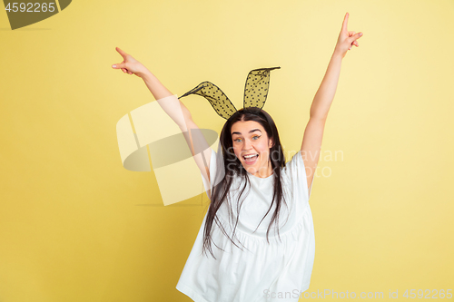 Image of Easter bunny woman with bright emotions on yellow studio background