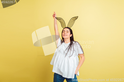 Image of Easter bunny woman with bright emotions on yellow studio background