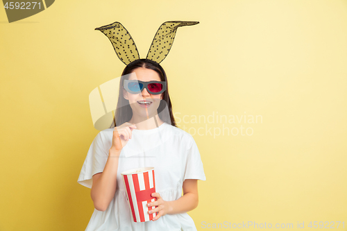 Image of Easter bunny woman with bright emotions on yellow studio background