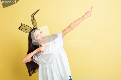 Image of Easter bunny woman with bright emotions on yellow studio background