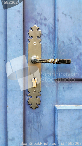 Image of Vintage wooden blue door with metallic handle and keyhole