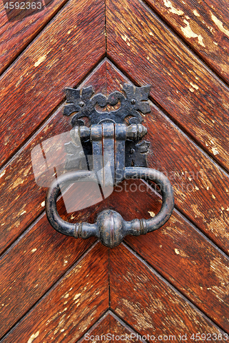 Image of Vintage doorknocker close-up on wooden door background