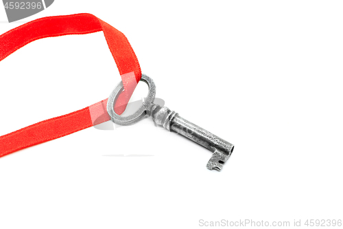 Image of Vintage silver key with red ribbon on white background