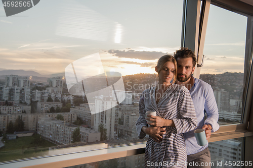 Image of young couple enjoying evening coffee by the window