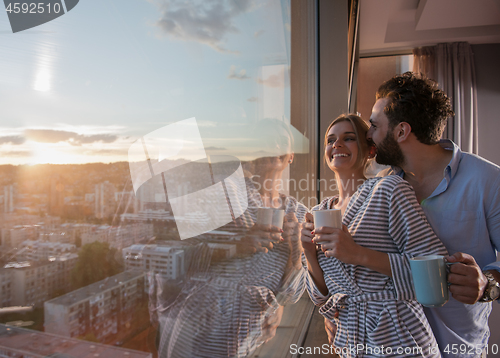 Image of young couple enjoying evening coffee by the window