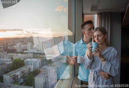 Image of young couple enjoying evening coffee by the window