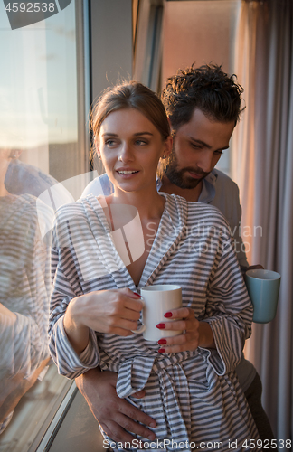 Image of young couple enjoying evening coffee by the window