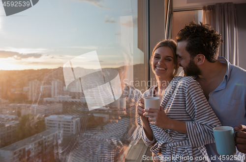 Image of young couple enjoying evening coffee by the window