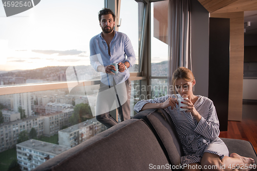 Image of young couple enjoying evening coffee by the window