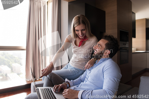 Image of couple relaxing at  home using laptop computers