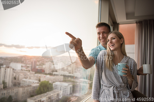 Image of young couple enjoying evening coffee by the window