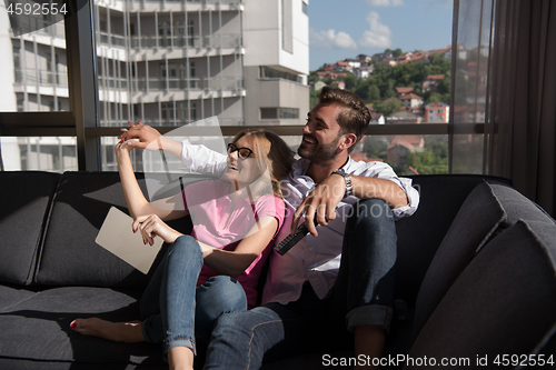 Image of Young couple watching television