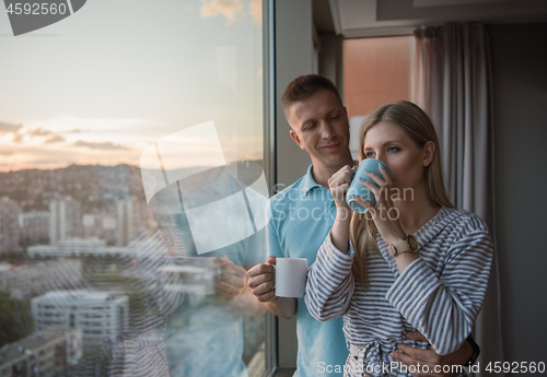 Image of young couple enjoying evening coffee by the window