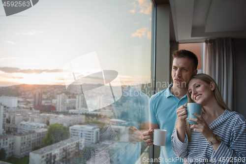 Image of young couple enjoying evening coffee by the window