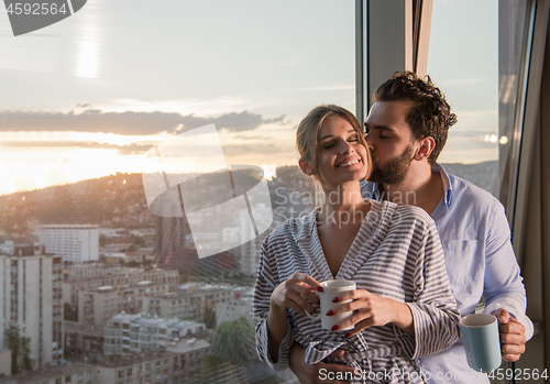 Image of young couple enjoying evening coffee by the window