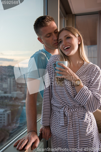 Image of young couple enjoying evening coffee by the window