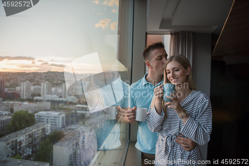 Image of young couple enjoying evening coffee by the window