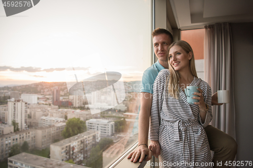 Image of young couple enjoying evening coffee by the window