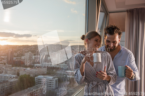 Image of young couple enjoying evening coffee by the window