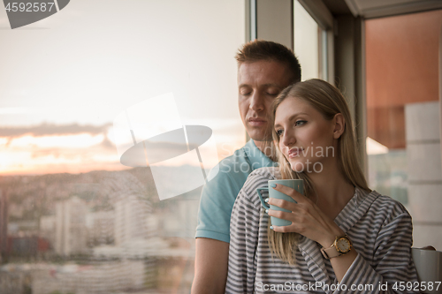 Image of young couple enjoying evening coffee by the window