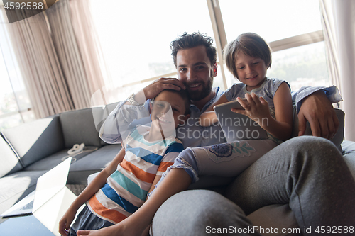 Image of happy young father spending time with kids